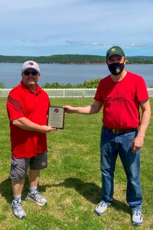 Clayton Harvey being presented with the Minor Hockey Association Volunteer of the Year Awards from Association President René Haché
